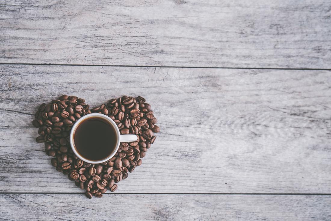 coffee cup in a heart made from coffee beans