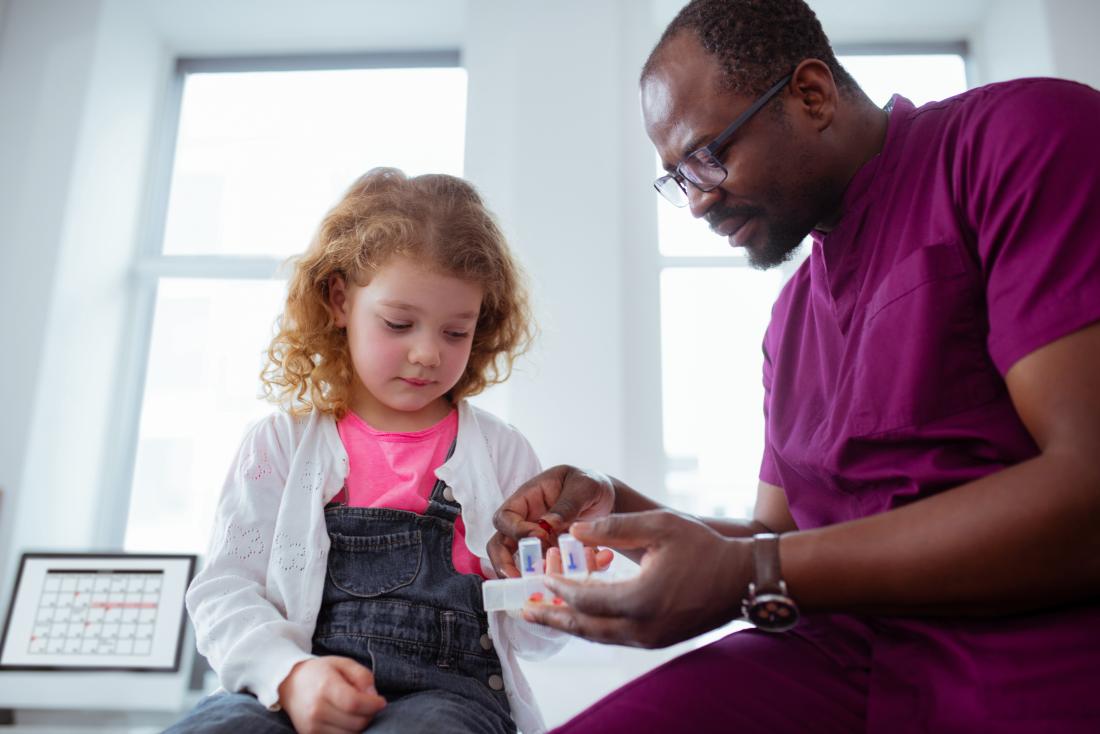 Child with doctor or pediatrician with medication or medicine prescription