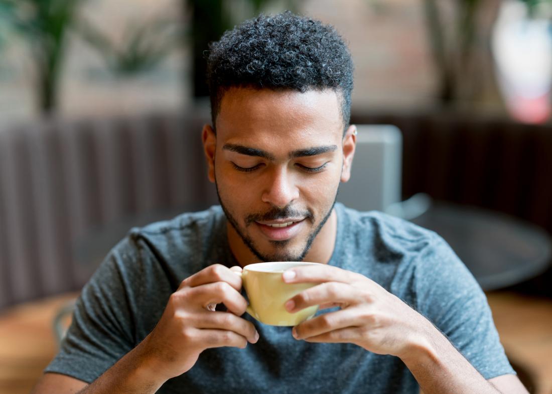 man looking at coffee cup